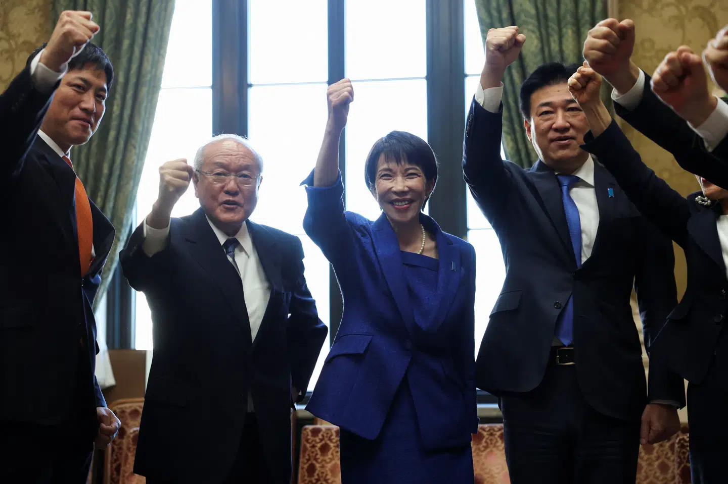 Premierminister Sanae Takaichi løfter næven sammen med sine partifæller, mens de råber "ganbaro", der er en opmuntrende japansk vending, der bruges til at vise støtte og motivere sig selv og andre.