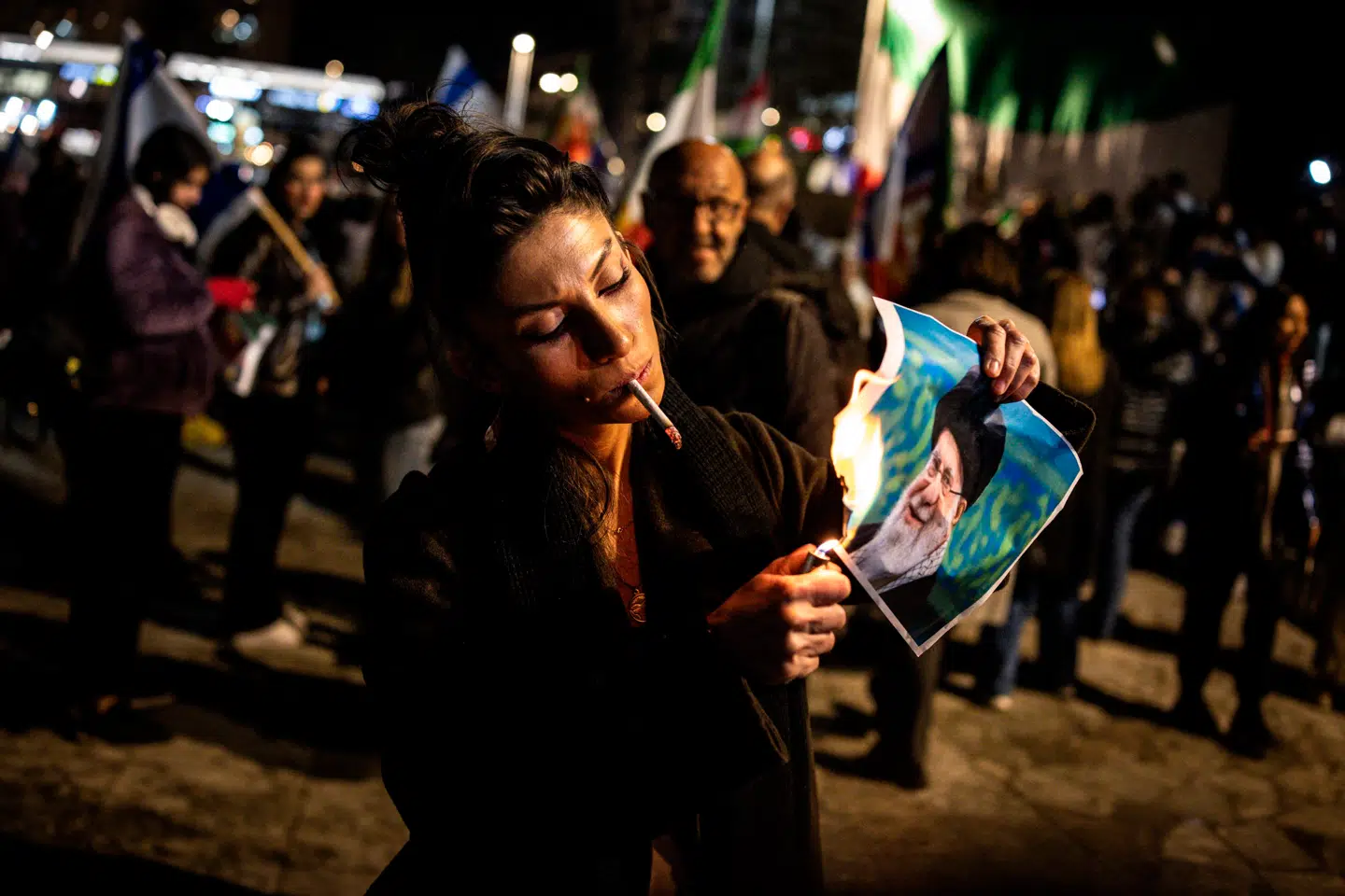 Iran fortjener vores opmærksomhed, skriver Amalie Lyhne i denne leder. Her har en kvinde i den israelske by Holon først tændt en cigaret og derefter sat ild til et billede af Irans ayatollah Ali Khamenei, 14. januar 2026.