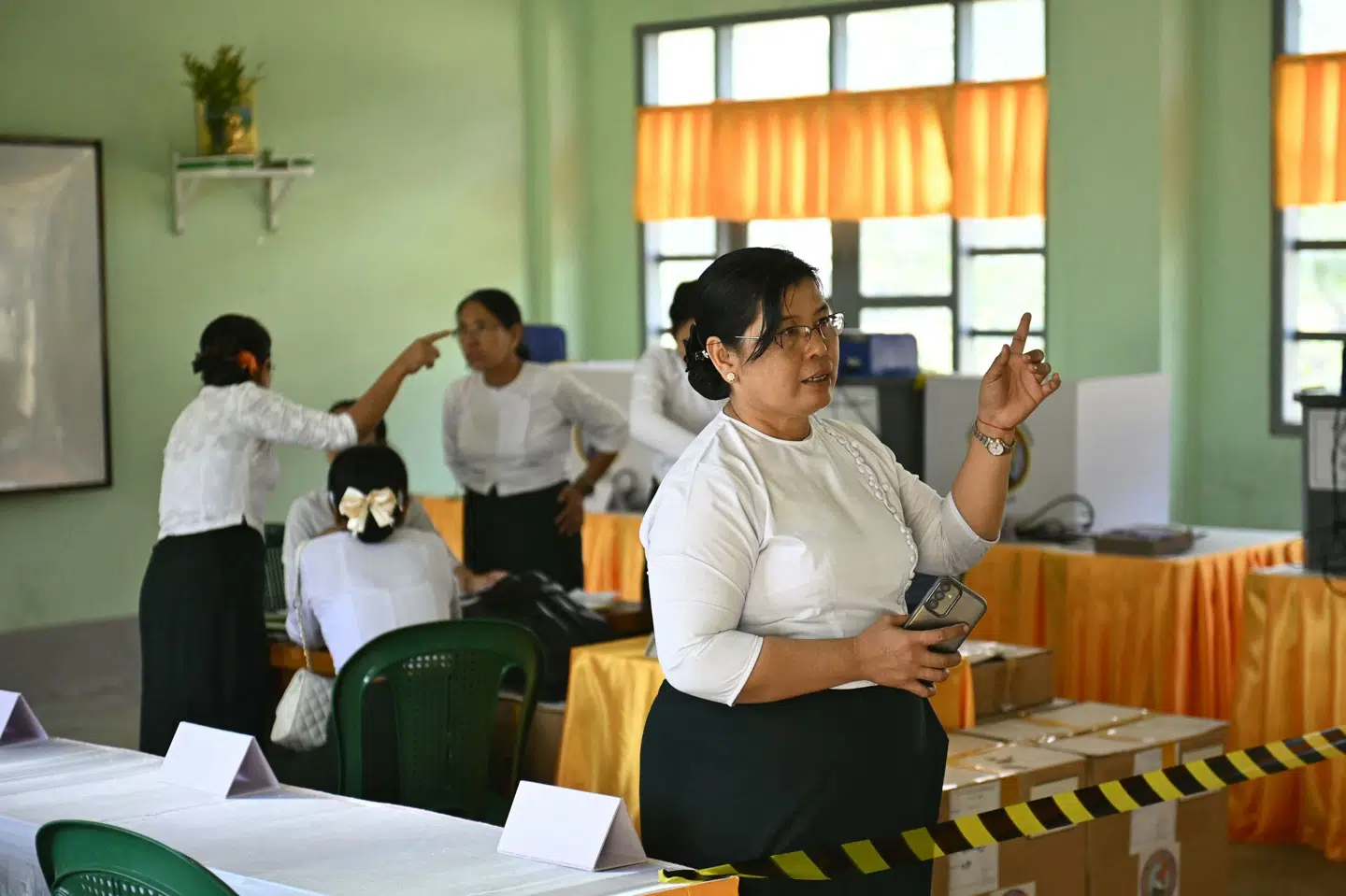 Frivillige satte lørdag valgmaskiner op ved et valgsted i Yangon forud for den sidste og tredje valgrunde søndag. (Arkivfoto).