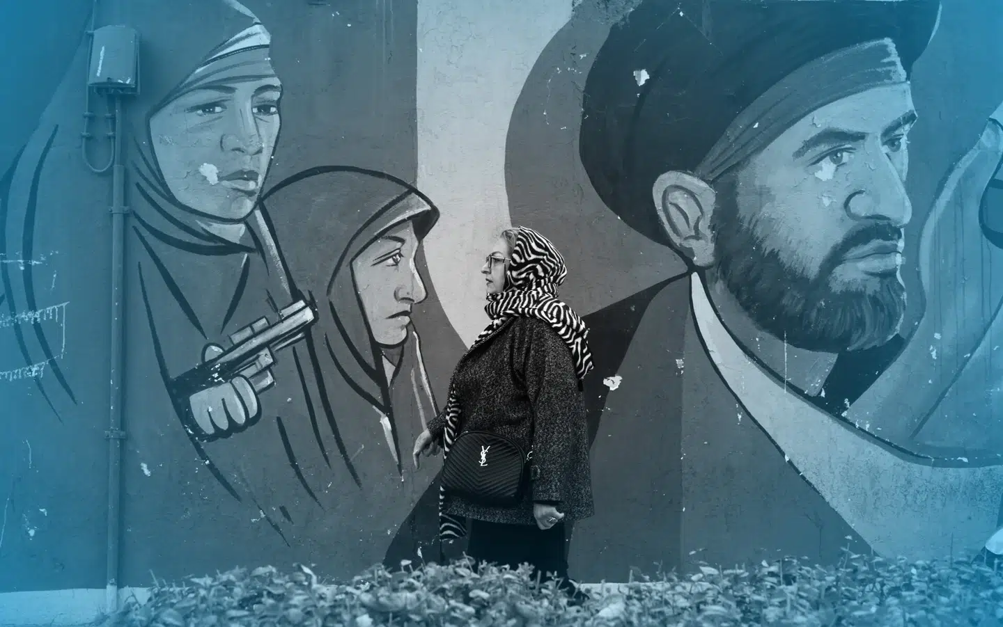 En kvinde går forbi et vægmaleri af iranske soldater i Teheran 29. januar 2026. Foto: Abedin Taherkenareh/EPA/Ritzau Scanpix