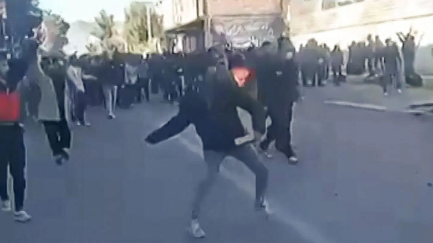 Et grynet billede af den demonstrant i færd med at kaste noget mod en regeringsbygning i Fasa i det sydlige Iran 2. januar.