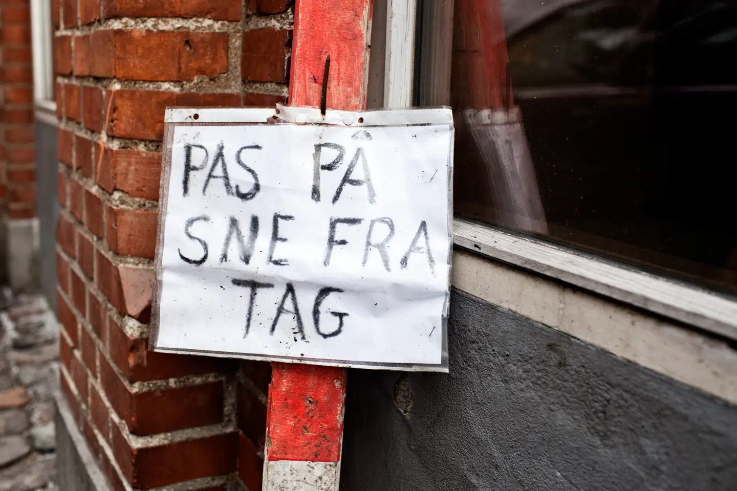 Flere steder falder der nu is og sne ned fra tagene.