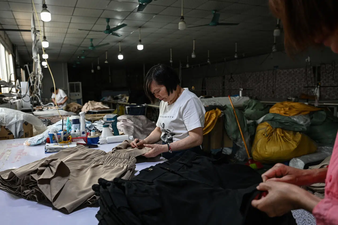 En syerske producerer tøj på en fabrik i det sydlige Kinas Guangdong-provins. Tøjet skal senere sælges via netbutikken Temu, som har indgået en aftale om affaldshåndtering. (Arkivfoto).