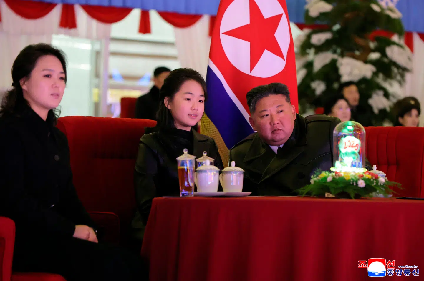 Kim Ju-ae ses her sidde i midten mellem sine forældre: Ri Sol-ju og Kim Jong-un. Billedet blev udsendt af Nordkoreas officielle nyhedsbureau Korean Central News Agency (KCNA) den 1. januar.