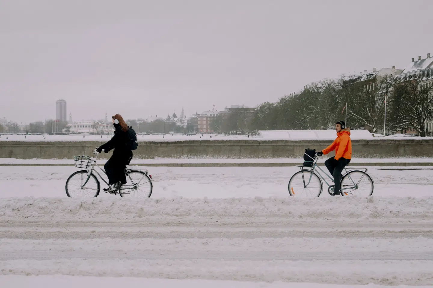 To cyklister træder sig gennem sneen i København.