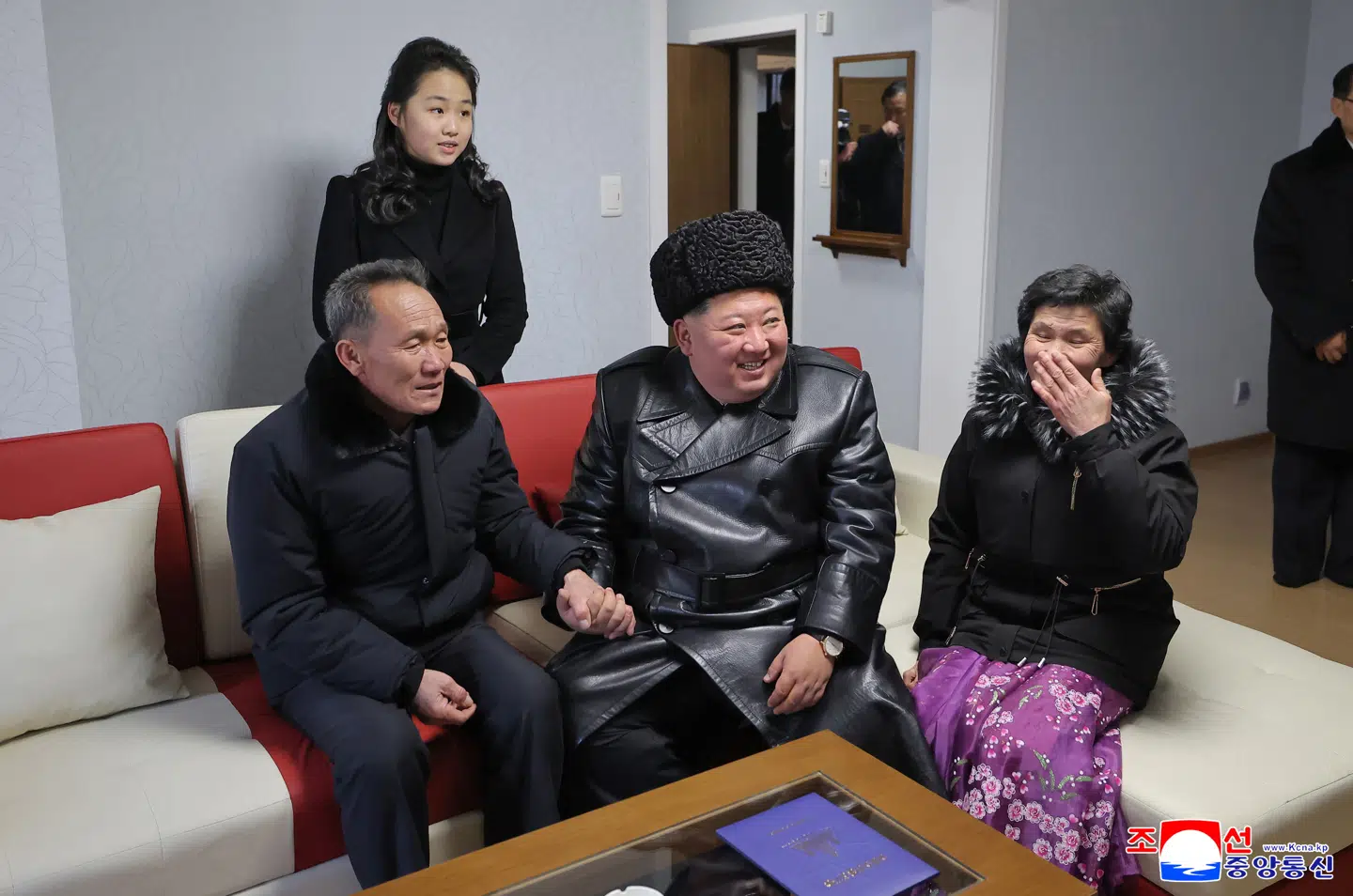 Kim Jong-un på besøg hos en af familierne. Bemærk datteren i baggrunden.