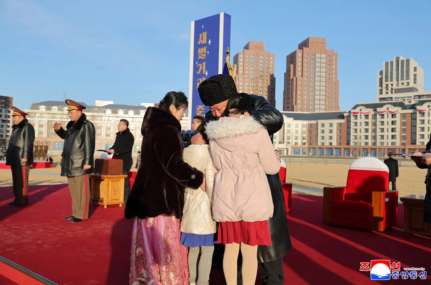 Nogle af de nye indbyggere i bydelen får et kram af Nordkoreas leder.