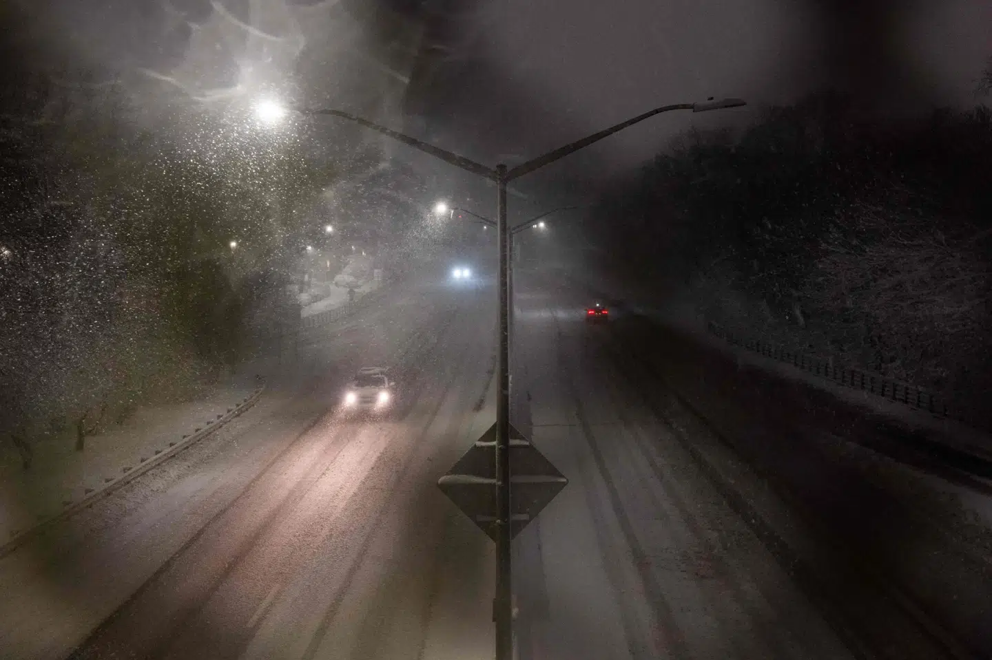 Få biler kører på en motorvej, mens sne begynder at falde natten til mandag dansk tid i bydelen Brooklyn i New York. Myndighederne fraråder alle unødvendige rejser på grund af en kraftig snestorm.