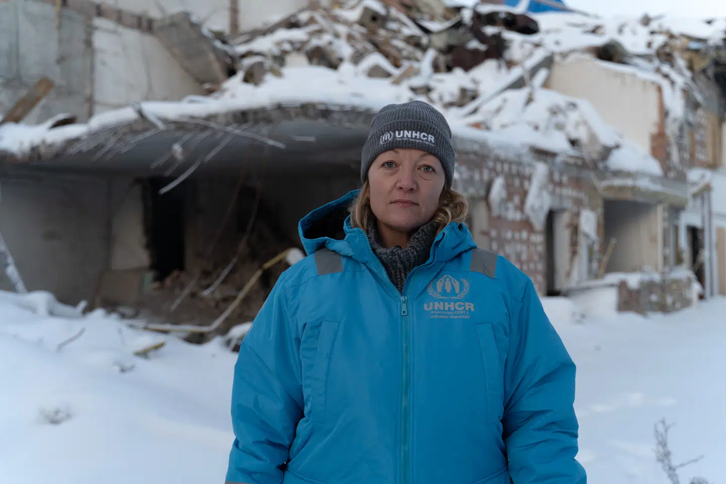 Vi må ikke vende blikket væk fra Ukraine, lyder opfordringen fra Elisabeth Haslund, der er talsperson og kommunikationschef for UNHCR, FNs Flygtningeorganisation, og som har boet i Ukraine de sidste to et halvt år. Her står hun foran en bygning i Kyiv, der er blevet ødelagt af et russisk angreb, i januar 2026. Foto: UNHCR/Alina Kovalenko
