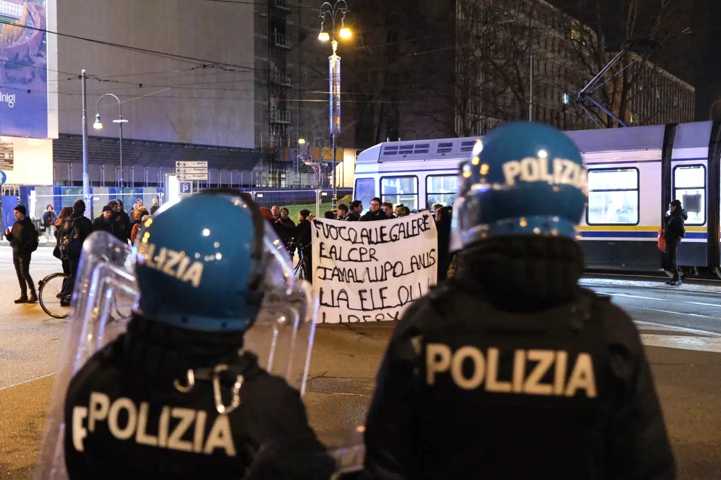 Urobetjente holder øje med demonstranter i den italienske by Torino. Reformer og lovændringer, der skal give dem bedre arbejdsvilkår, har fået et skud for boven, efter at en kollega mandag blev fængslet for mord.