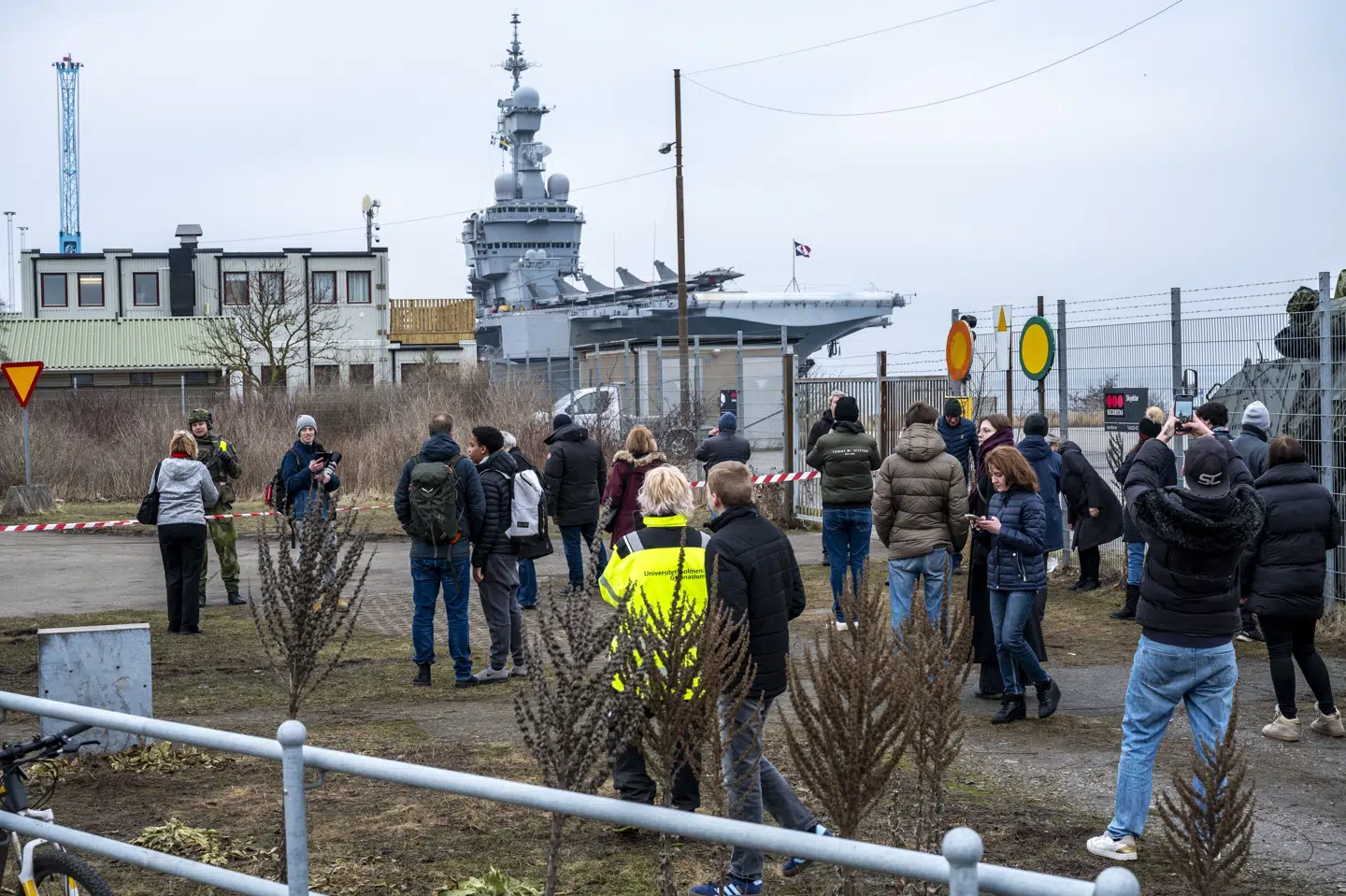 Nysgerrige folk prøver at få et glimt og et billede af et kæmpe fransk hangarskib, som en russisk drone onsdag angiveligt var på vej mod.