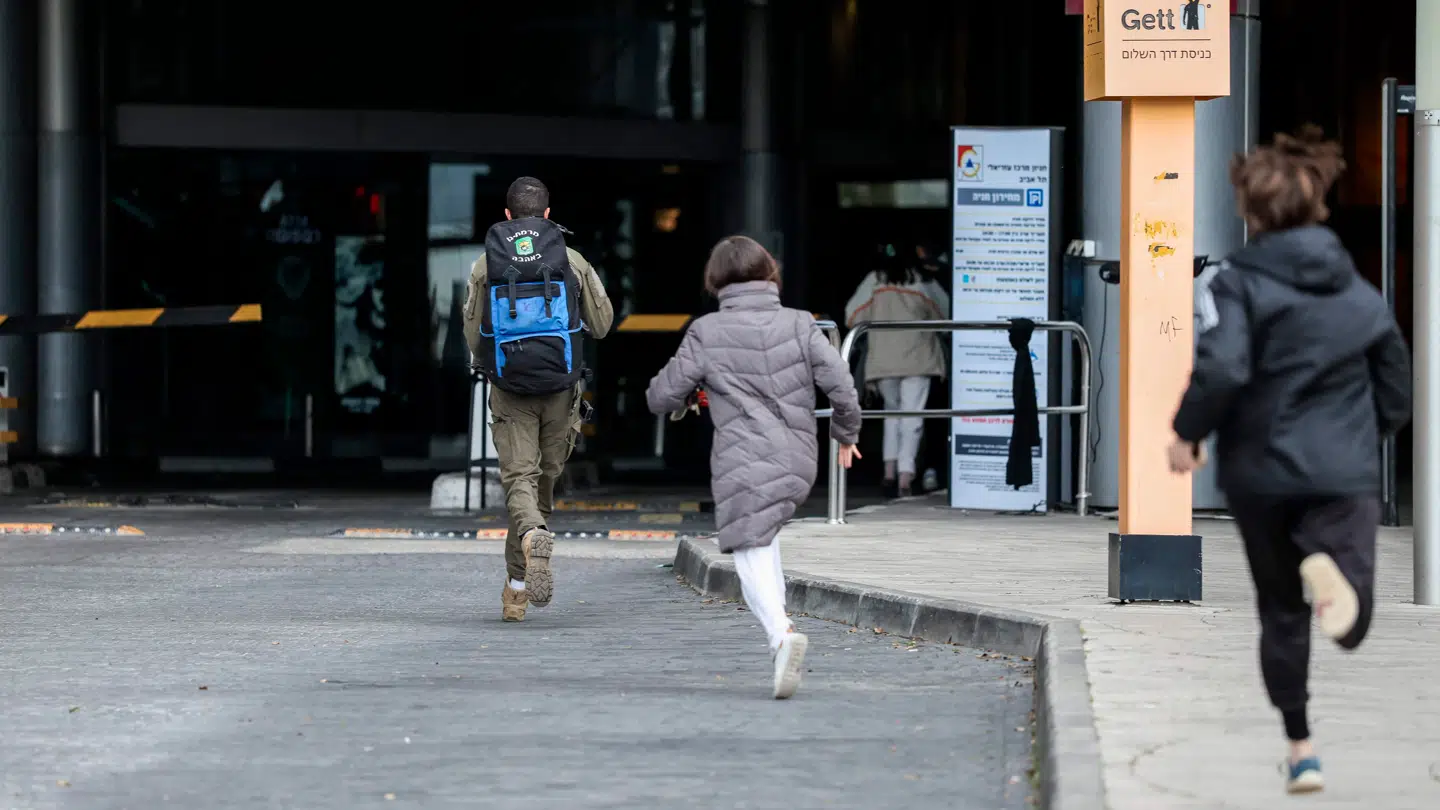 På billedet ses folk, der lørdag løber i beskyttelsesrum efter sirener i Tel Aviv.