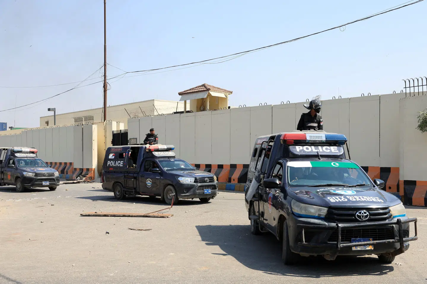 Politibiler holder foran USA's konsulat i pakistanske Karachi efter en proiransk demonstration.