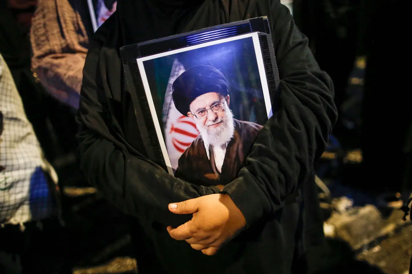 En kvinder holder et portræt af Irans øverste leder, ayatollah Ali Khamenei, under en solidaritetsprotest uden for USA's ambassade i Malaysias hovedstad, Kuala Lumpur. Billedet er fra søndag.
