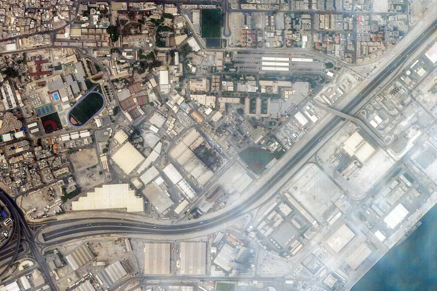 Et satellitbillede viser røg stige op over Bahrains hovedstad, Manama, efter et iransk angreb på en amerikansk militærbase natten til mandag.