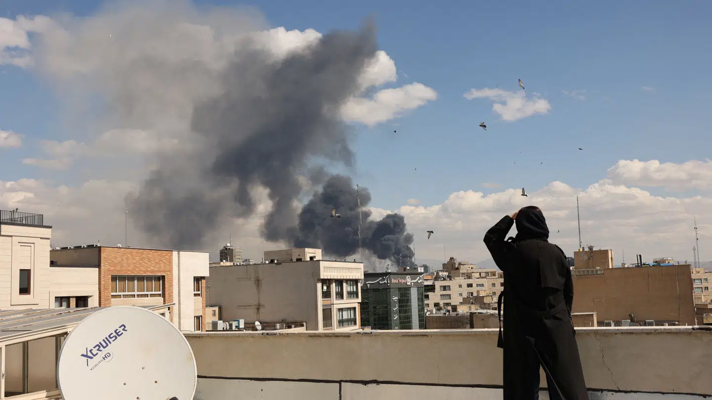 En kvinde ser på røgen fra endnu et amerikansk angreb i den iranske hovedstad, Teheran, 1. marts. Umiddelbart tyder meget på, at USA og Israel kun kan holde det nuværende tempo i nogle få uger mere.