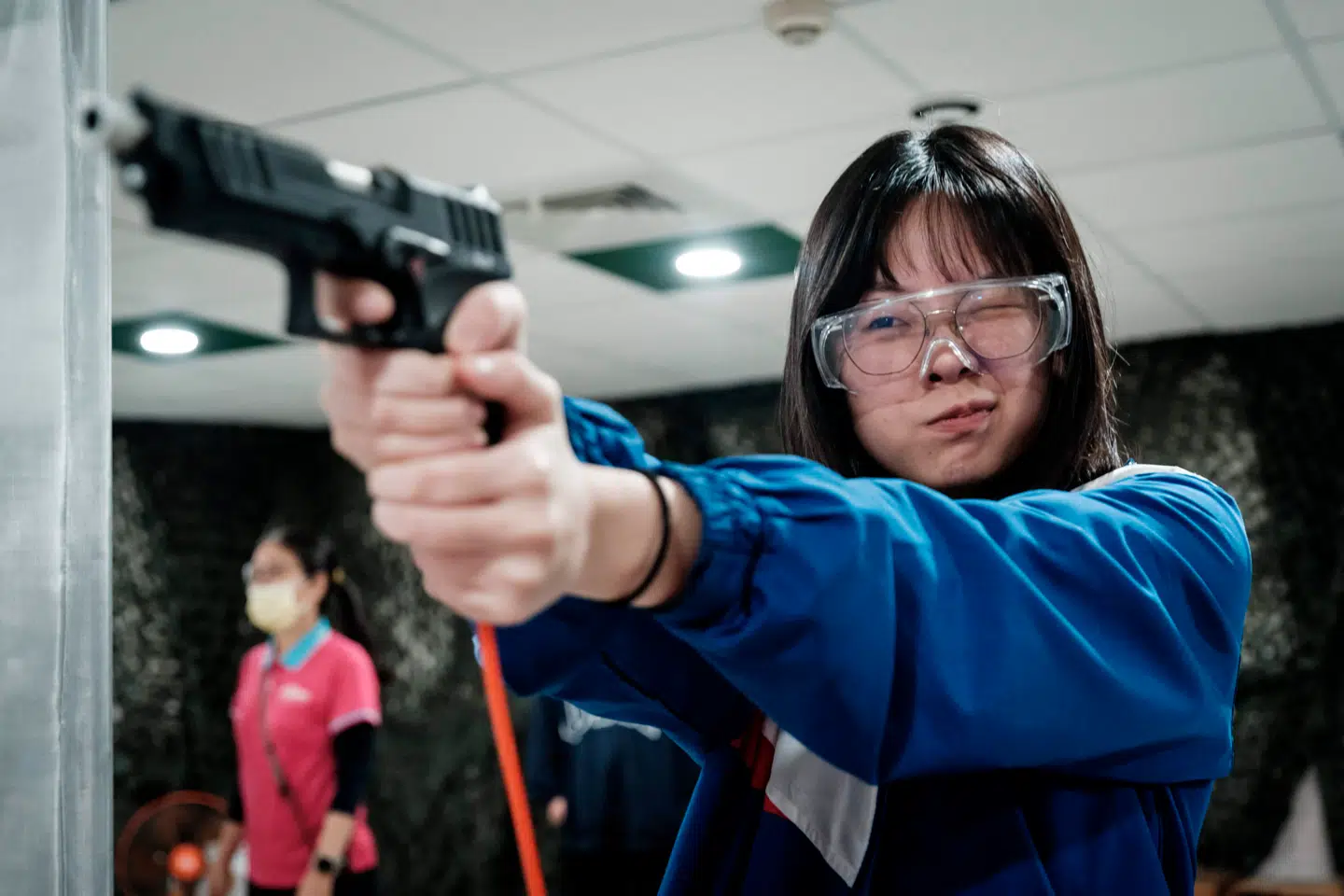 Taiwan er under voksende pres, og nogle går så vidt som til at træne i kamp og førstehjælp for at være klar, hvis Kina en dag gør alvor af sine trusler og angriber øen. Her ses en kvinde træne med luftpistol i byen Kaohsiung.