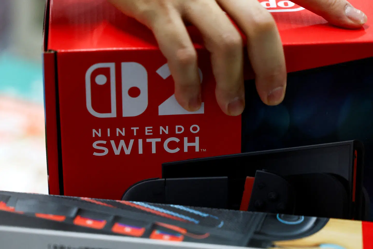FILE PHOTO: A person holds a Nintendo Switch 2 game console's box as Nintendo starts selling the new consoles globally, at an electronics store in Tokyo, Japan June 5, 2025. REUTERS/Issei Kato/File Photo