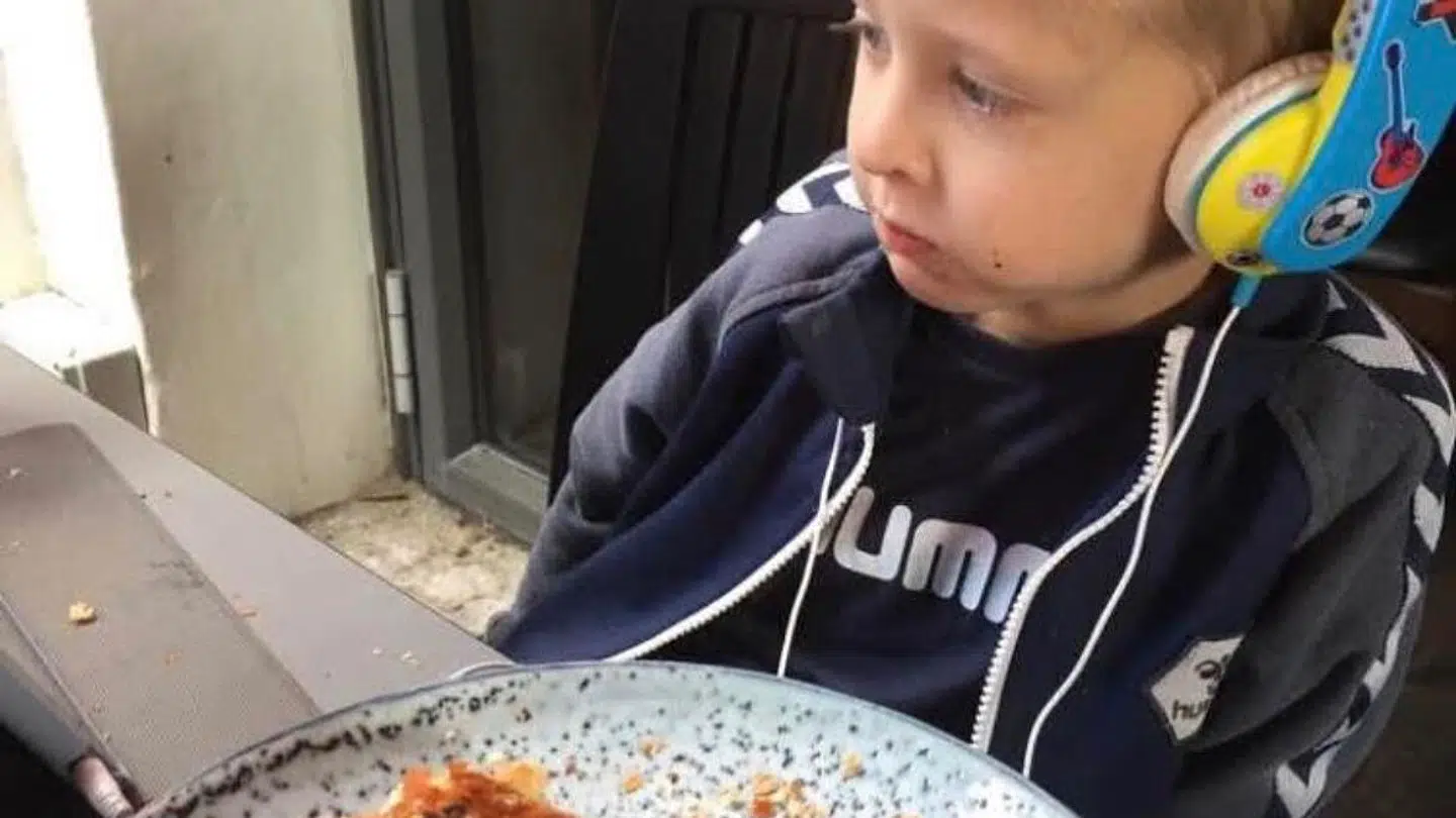 En typisk spisesituation i familien Ivarsen kunne se sådan her ud. Magnus med iPad og hovedtelefoner og en burger, som han får lov at spise i sit helt eget tempo.