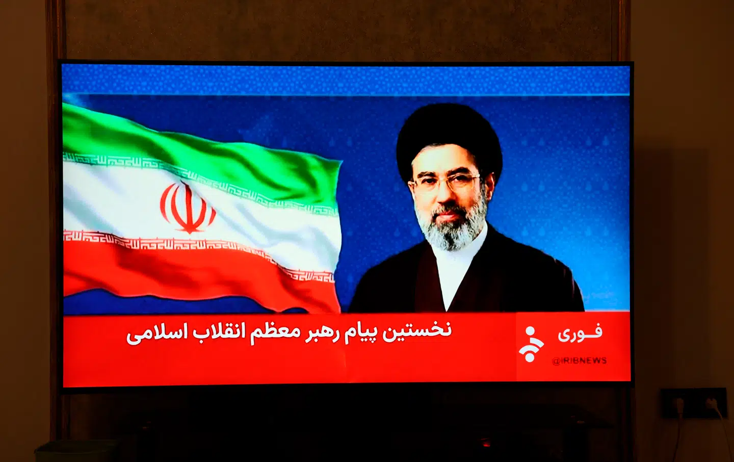Talen blev læst op af en kvindelig tv-vært, mens et stilbillede af Mojtaba Khamenei blev vist på skærmen ved siden af et bølgende iransk flag.