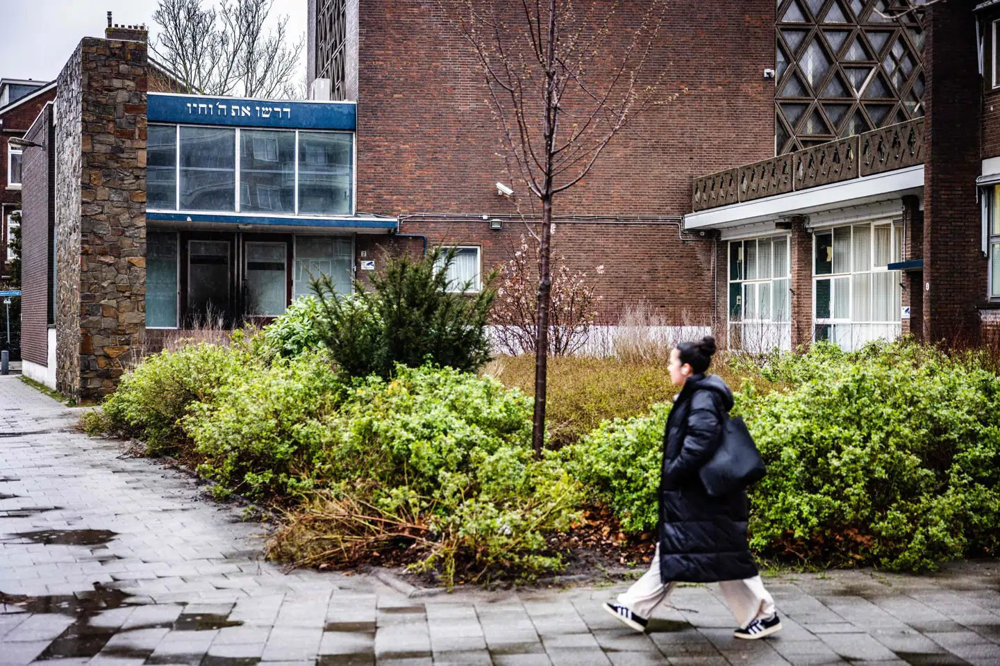 En kvinde går forbi synagogen i Rotterdam, som natten til fredag blev udsat for et brandangreb.