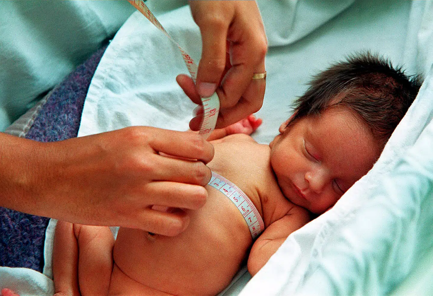 ILLUSTRATIVT. En sygeplejerske måler en nyfødt pige.