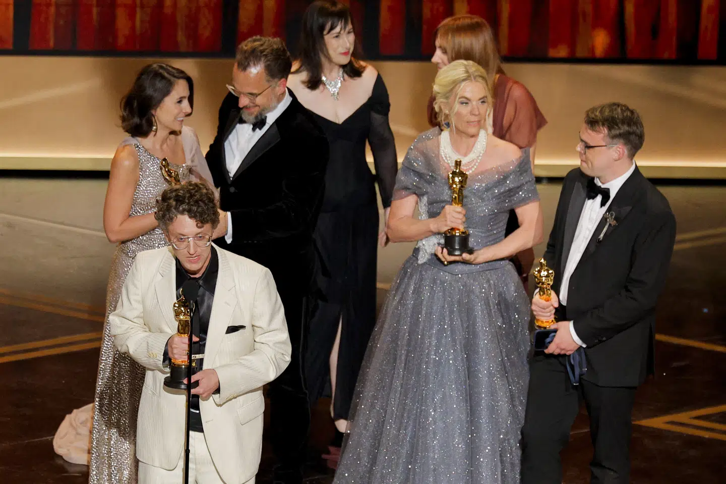 På billedet ses danske Helle Faber i højre side holde oscarstatuetten, mens instruktøren David Borenstein holder tale på scenen.