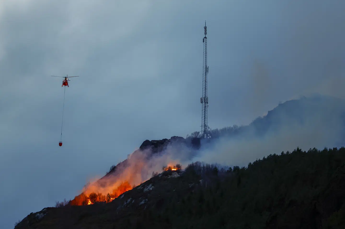 Branden i Ålesund er ikke under kontrol, og der er fare for spredning, skriver NRK. Vinden i fjeldet har ført til, at et stort område brænder. Beboelse og personer