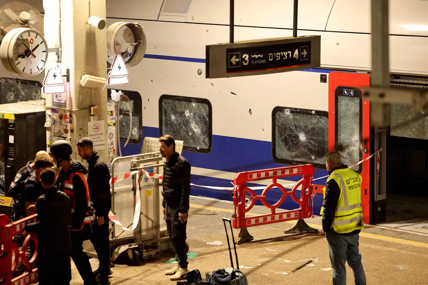 Medlemmer af Israels sikkerhedsstyrker og redningspersonale står på en togstation, der er blevet ramt af fragmenter efter et iransk angreb på storbyen Tel Aviv natten til onsdag.