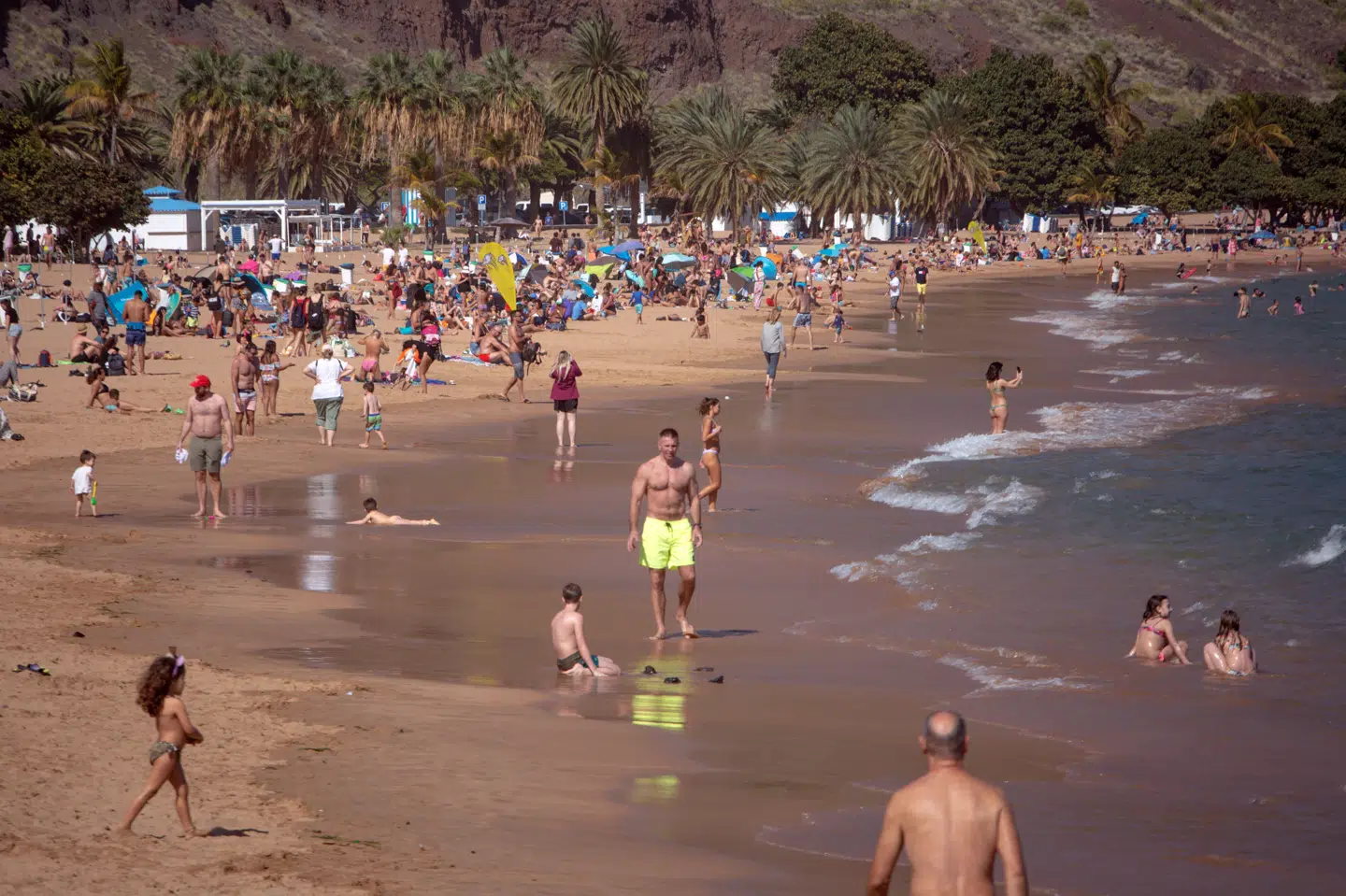 Solen bager, mens strandgæster bader på stranden Las Teresitas ved Santa Cruz på ferieøen Tenerife 11. marts 2023. Onsdag har myndighederne aktiveret øens nødplan, fordi der er udsigt til vildt vejr. (Arkivfoto).