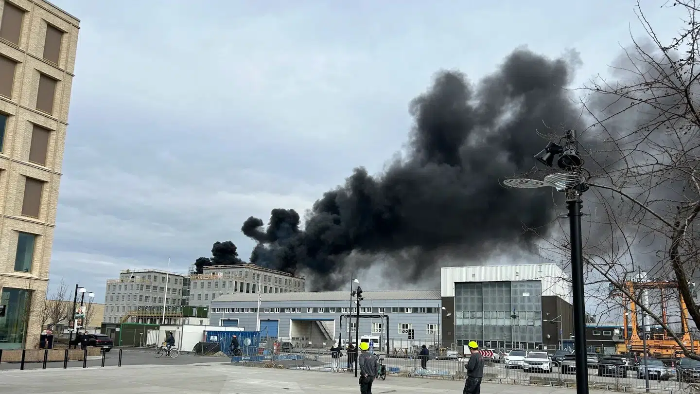 Sort røg stiger op fra bygningen, der er i brand.