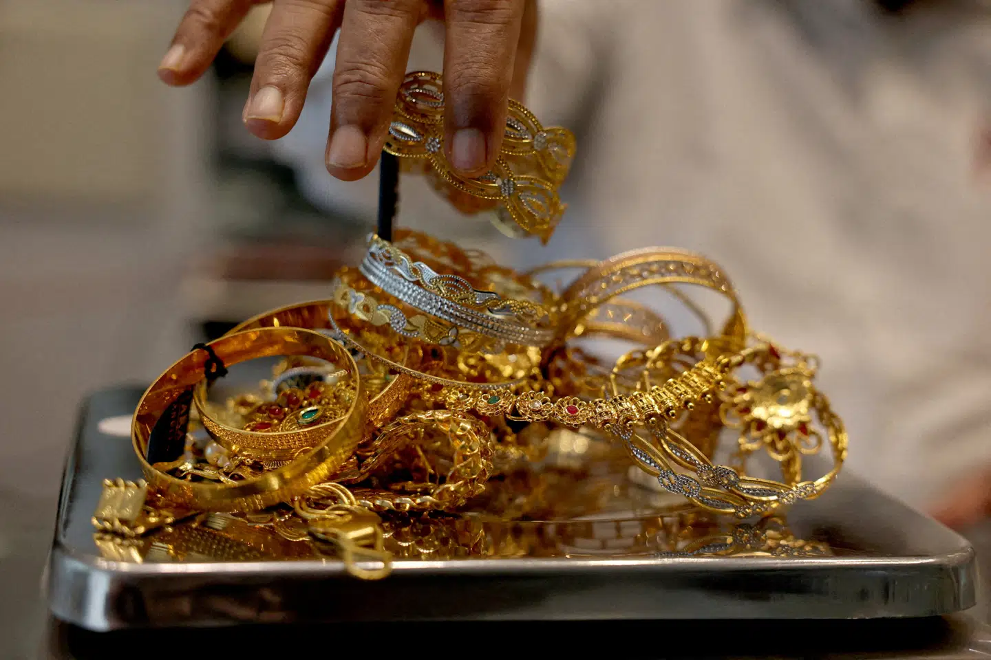 FILE PHOTO: A goldsmith weighs gold jewellery inside a showroom in Ahmedabad, India, July 31, 2025. REUTERS/Amit Dave/File Photo