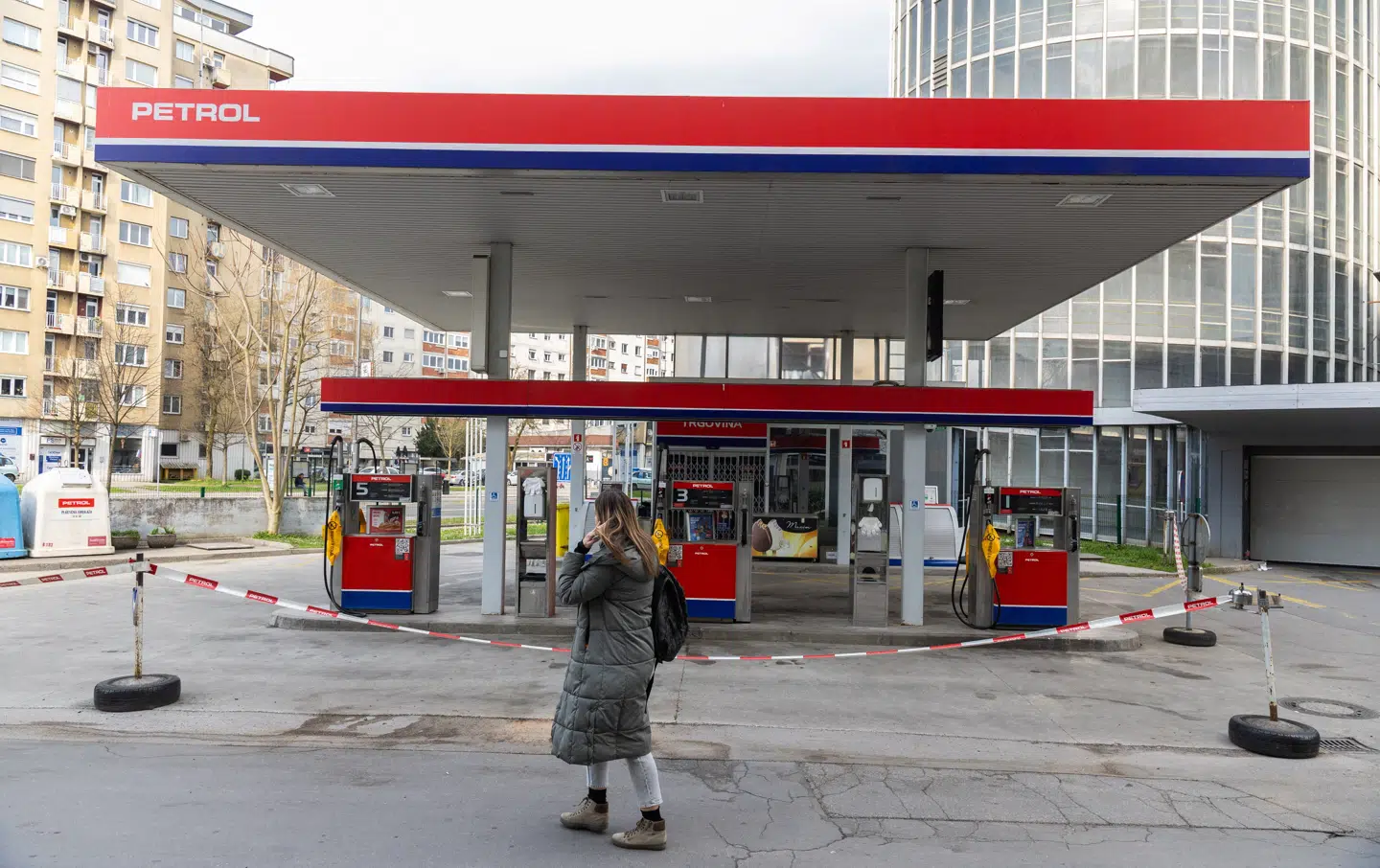 En kvinde går forbi en lukket tankstation i den slovenske hovedstad, Ljubljana, søndag.