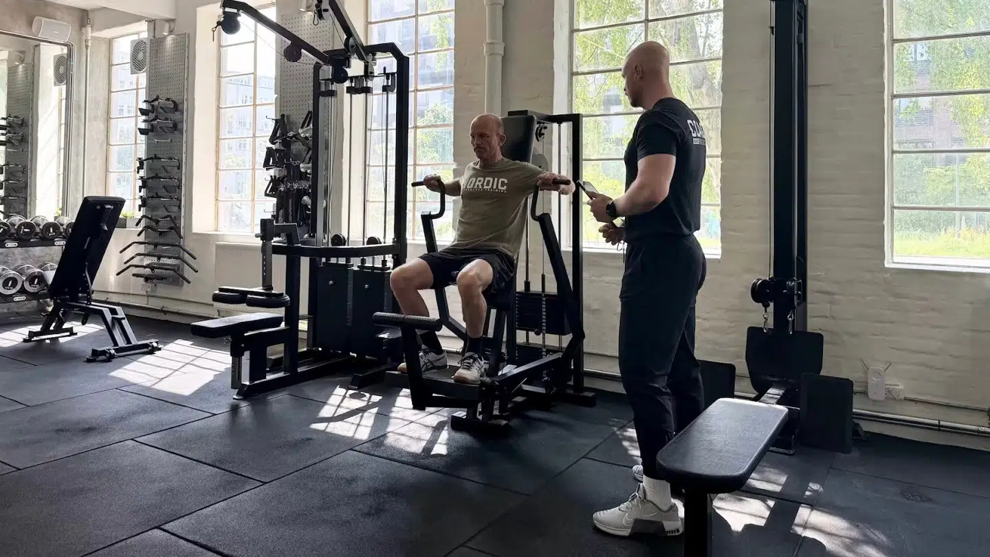 Autoriseret fysioterapeut vejleder klient gennem struktureret styrketræning i et privat træningscenter i København