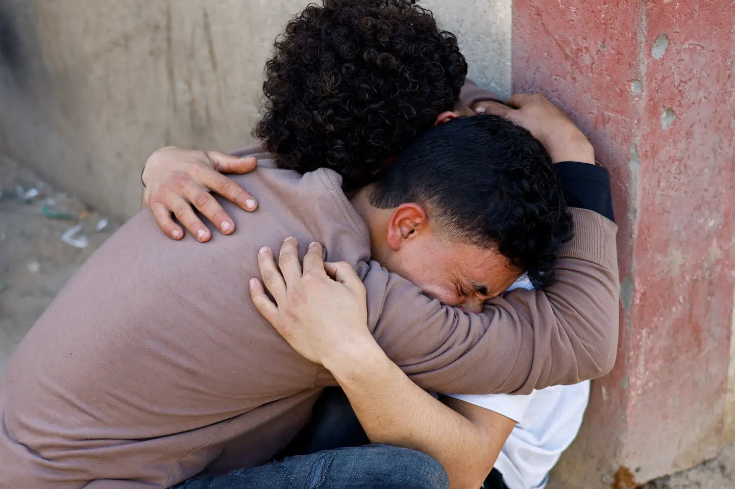 Palæstinensere omfavnede mandag hinanden efter et israelsk angreb uden for en skole, der ifølge medicinsk personale, som nyhedsbureauet Reuters har talt med, huser fordrevne mennesker i Gaza. (Arkivfoto).