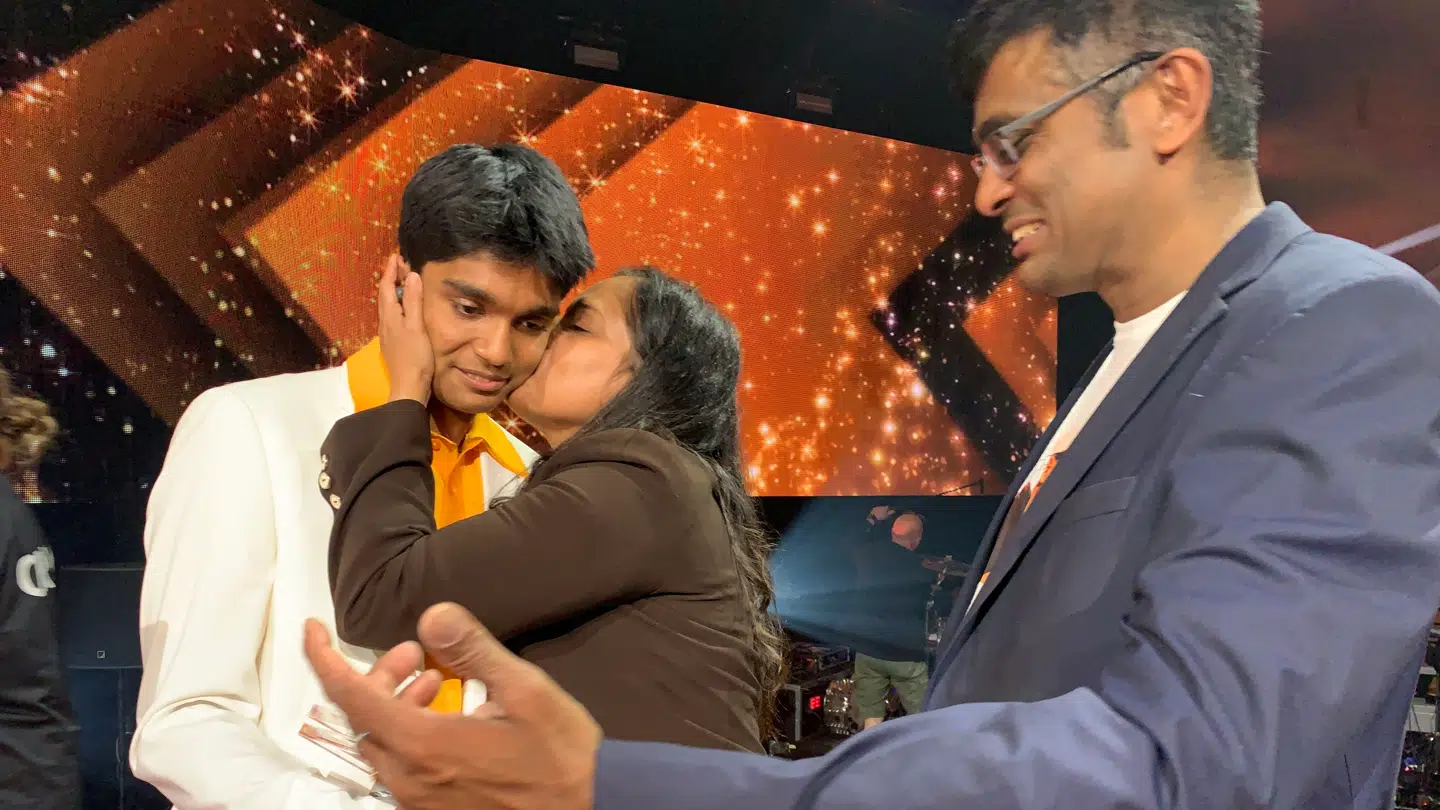 Hugo lykønskes af sine forældre på scenen.