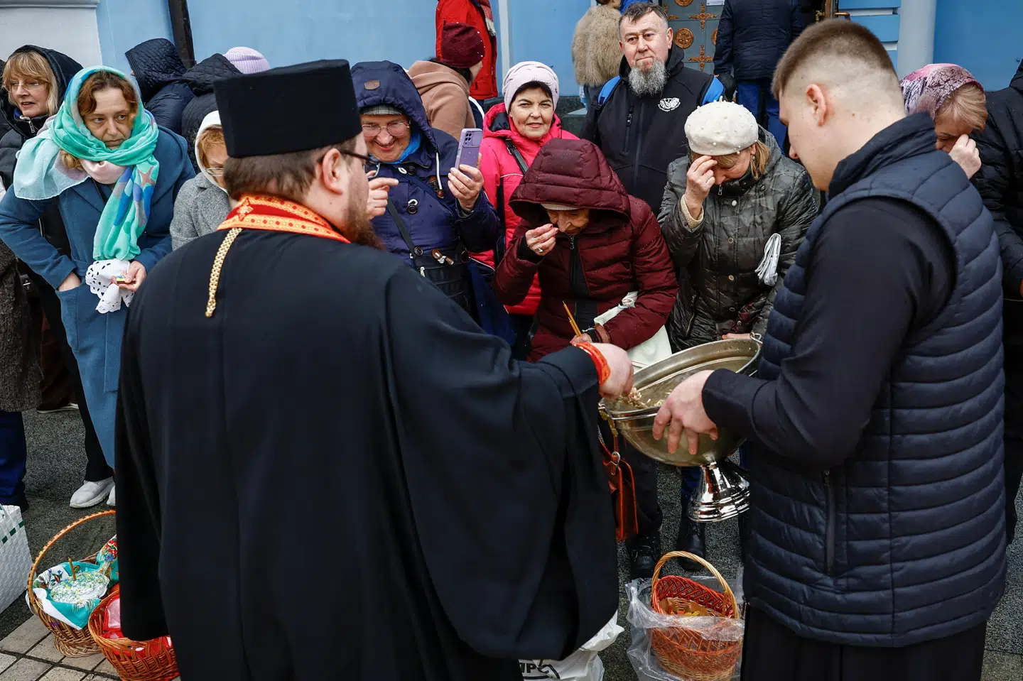 En præst sprøjter helligt vand ud over påskekager under en ceremoni forud for ortodoks påske i Ukraines hovedstad, Kyiv, mens Rusland angiveligt stadig angriber nabolandet.