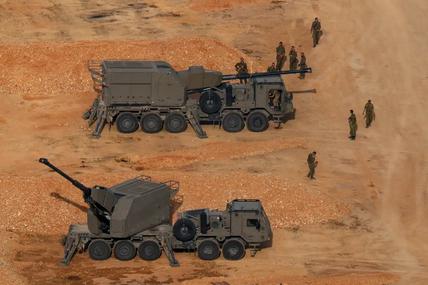 På billedet ses israelske soldater stå nær kampvogne ved den israelsk-libanesiske grænse i det nordlige Israel onsdag.