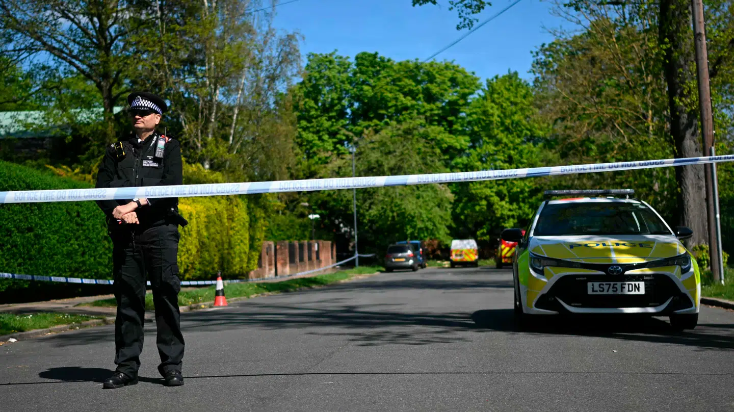 En politibetjent står inden for en afspærring, der er oprettet nær synagogen, hvor hændelsen skete.