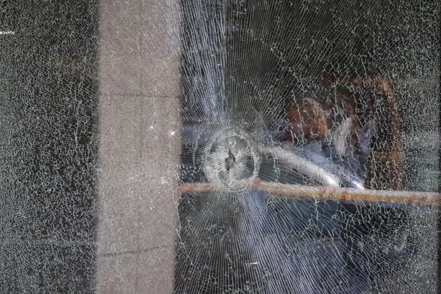 Et skudhul kan ses i et vindue ind til det supermarked i Kyiv, hvor gerningsmanden holdt flere mennesker som gidsler lørdag.