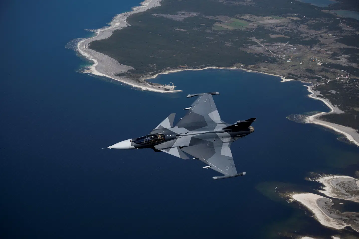 Et svensk jagerfly af modellen JAS 39 Gripen E flyver over øen Gotland i Østersøen. Øen ligger cira 350 kilometer fra den russiske enklave Kaliningrad og er omdrejningspunkt i ét ud af i alt syv trusselsscenarier, som bliver introduceret i en opsigtsvækkende svensk forsvarsstrategi.