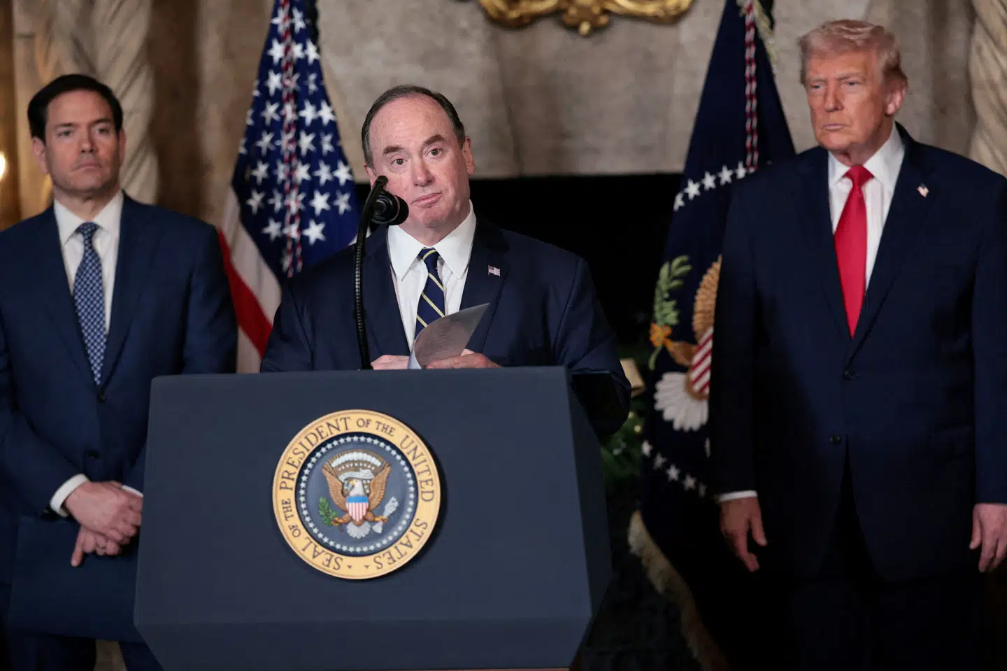 Flådeminister John Phelan ses i december sidste år udtale sig i Florida med Donald Trump i baggrunden. Phelan fratræder ifølge Pentagon øjeblikkeligt sin post. (Arkivfoto).