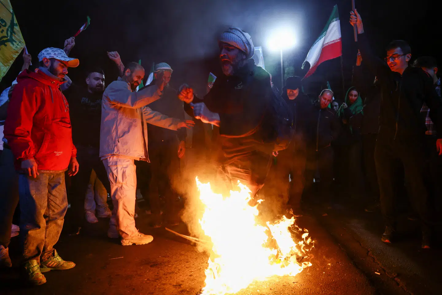 En mand tramper på brændende amerikanske og israelske flag i Irans hovedstad Teheran efter offentliggørelsen af våbenhvilen den 8. april.