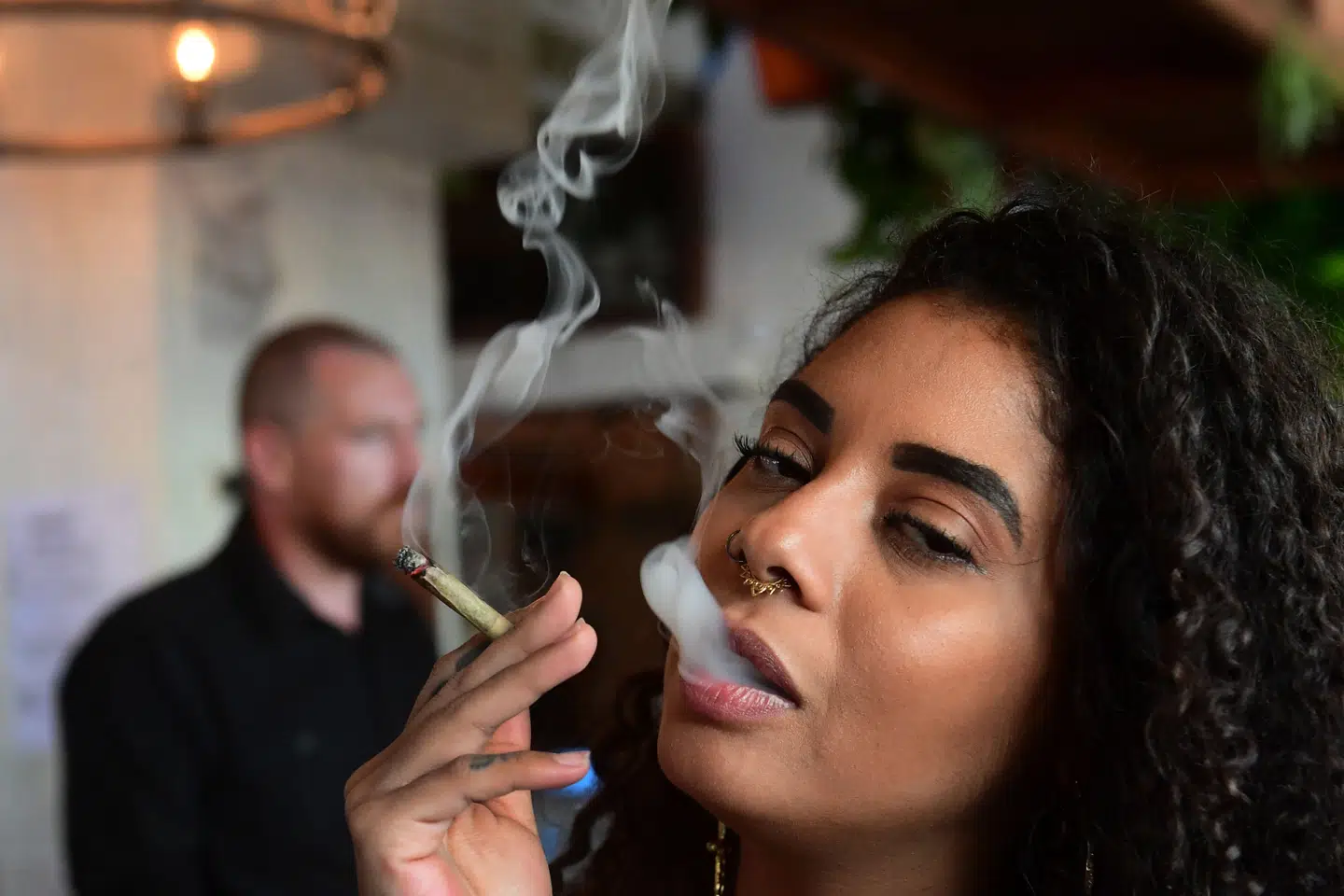 I Californien, hvor en kvinde ryger en joint på en cafe i West Hollywood, er der ret lempelige cannabisregler. (Arkivfoto).