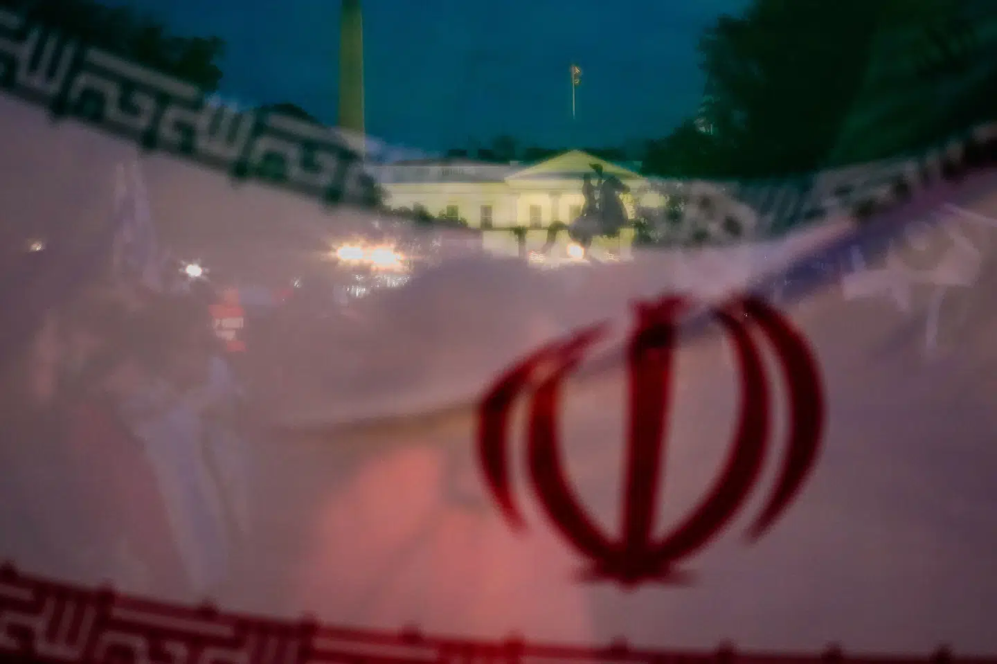 Våbenhvile mellem Iran og USA har varet over to uger, men er skrøbelig. Her ses Det Hvide Hus gennem et iransk flag under demonstrationer. (Arkivfoto).