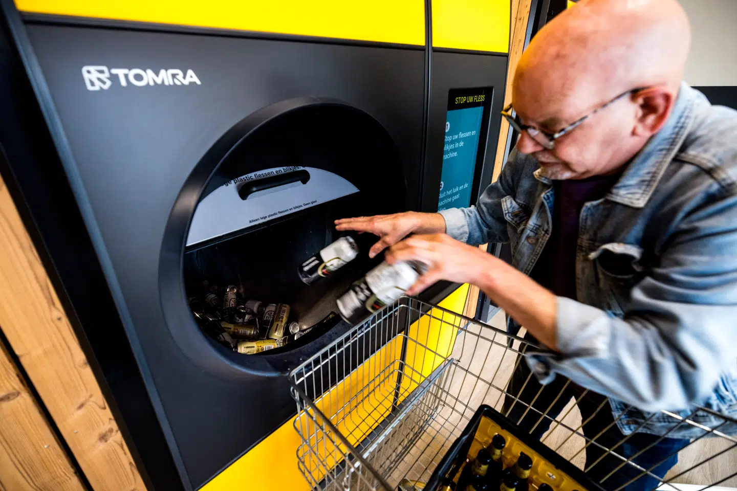 A consumer hands in cans at a deposit machine from the Tomra company in a Jumbo branch, in Eerbeek, on September 29, 2023. ROB ENGELAAR / ANP / AFP