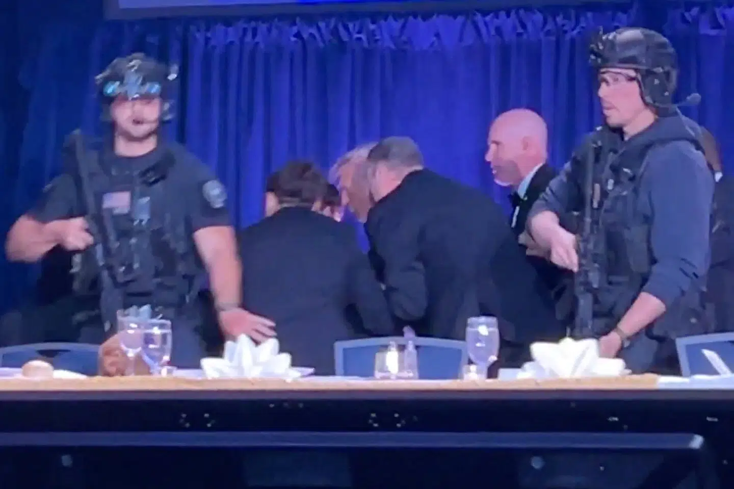 Et skærmbillede fra en video viser USA's præsident, Donald Trump, blive eskorteret væk fra den årlige korrespondentmiddag i Washington D.C. efter et skyderi.