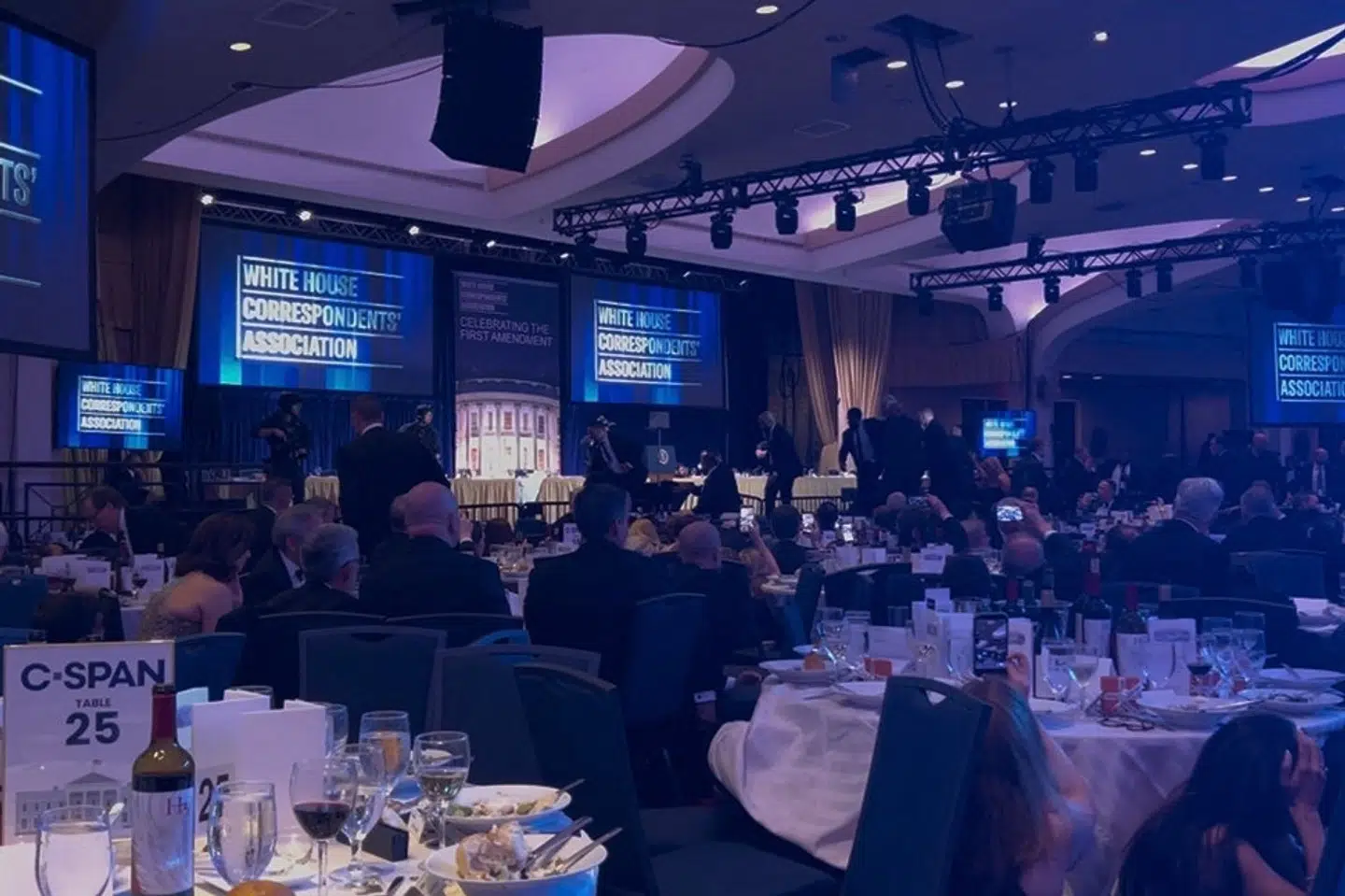 Agenter på vej mod scenen i balsalen, efter at der blev hørt høje brag ved pressemiddagen.