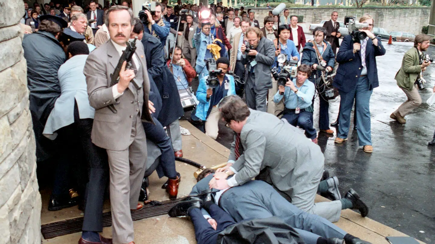 Der opstod fuldstændig kaos efter attentatet mod Ronald Reagan. Billedet viser øjeblikket umiddelbart efter skyderiet, hvor præsidenten er kørt væk. I baggrunden ses politi og sikkerhedsfolk, som har overmandet gerningsmanden, mens andre forsøger at hjælpe pressesekretær James Brady og politibetjenten Thomas Delahanty, som ligger såret på jorden.