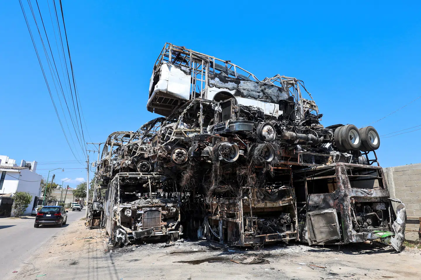 En bunke af udbrændte køretøjer ligger ved siden af vejen i Puerto Vallarta i Mexico i marts. Køretøjerne blev brugt af kriminelle til at blokere veje efter drabet på Nemesio Oseguera, som var leder af et kartel. (Arkivfoto).
